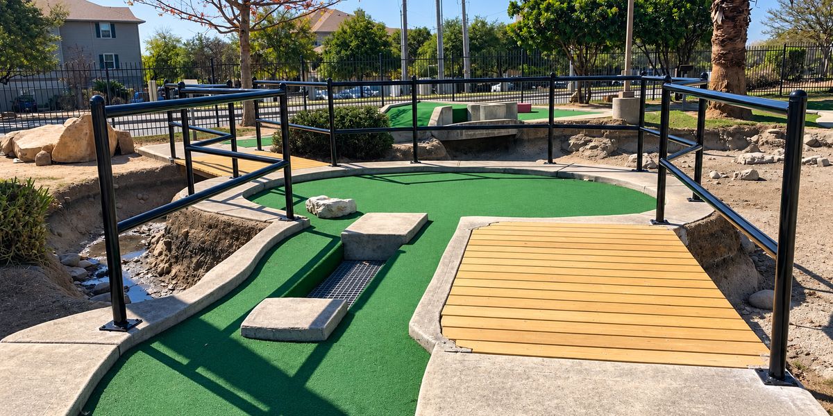 Custom black steel handrails installed along a mini golf course walkway